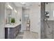 Modern bathroom features a marble shower, a double vanity, and a linen closet at 7140 Palmyra Ave, Las Vegas, NV 89117