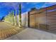Modern driveway gate with horizontal wood slats and elegant landscaping, providing privacy and curb appeal at 7140 Palmyra Ave, Las Vegas, NV 89117