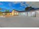 Exterior of the home showcasing a three-car garage and sleek design with stone accents and manicured landscaping at 7140 Palmyra Ave, Las Vegas, NV 89117
