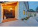 Inviting front entrance with stone facade, double doors, modern garage doors, and desert-friendly landscaping at 7140 Palmyra Ave, Las Vegas, NV 89117