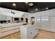 Open kitchen features island with marble countertops, and modern white cabinetry at 7140 Palmyra Ave, Las Vegas, NV 89117