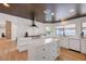 Modern kitchen with white cabinetry, stainless steel appliances, a central island, and hardwood floors at 7140 Palmyra Ave, Las Vegas, NV 89117