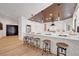 Open kitchen with bar seating, marble countertops, stainless steel appliances, and modern pendant lighting at 7140 Palmyra Ave, Las Vegas, NV 89117