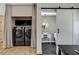 Well-organized laundry area with modern washer/dryer and stylish barn door leading to a half bath at 7140 Palmyra Ave, Las Vegas, NV 89117