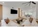 Open-concept living room with a large screen TV, modern sectional, and dining area, perfect for entertaining at 7140 Palmyra Ave, Las Vegas, NV 89117