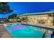 Backyard pool with vibrant lighting, lounge seating and covered patio at 7140 Palmyra Ave, Las Vegas, NV 89117
