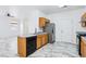 Bright, galley-style kitchen featuring oak cabinets and a modern stainless steel refrigerator at 7331 Carrot Ridge St, Las Vegas, NV 89139