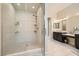 A modern bathroom showcasing a glass enclosed shower with sleek hardware, tiled walls, and dual vanities at 7340 Zonal Ave, Las Vegas, NV 89131