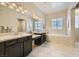 A bright bathroom featuring double sinks, a makeup vanity, soaking tub, and tile flooring for a luxurious experience at 7340 Zonal Ave, Las Vegas, NV 89131