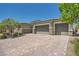 Large paver driveway leading to a three-car garage with stone accents on a sunny day at 7340 Zonal Ave, Las Vegas, NV 89131