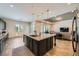 Open kitchen featuring a large island, dark cabinetry, stainless steel appliances, and a view of the living room at 7340 Zonal Ave, Las Vegas, NV 89131