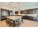 Gourmet kitchen featuring a large island with seating, stainless steel appliances, and custom cabinetry at 7340 Zonal Ave, Las Vegas, NV 89131