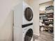 Modern laundry room featuring a stacked washer and dryer and ample storage shelving at 7340 Zonal Ave, Las Vegas, NV 89131