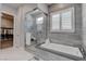 Elegant bathroom featuring soaking tub, glass shower, and access to walk-in closet at 7416 Deschutes Cir, Las Vegas, NV 89129