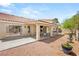 Backyard features a covered patio area with an outdoor dining set, desert landscaping, and block wall at 7736 Foredawn Dr, Las Vegas, NV 89123