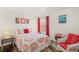Cozy bedroom showcasing a colorful bedspread, bright red curtains, and a comfortable rocking chair at 7736 Foredawn Dr, Las Vegas, NV 89123