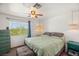 Bedroom features a ceiling fan, window with natural light, and views of the greenery outside at 7736 Foredawn Dr, Las Vegas, NV 89123