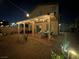 Backyard night scene featuring a covered patio with lights and desert landscaping at 7824 Warm Winds St, North Las Vegas, NV 89084