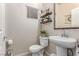 Cozy half bathroom featuring a pedestal sink, decorative shelves, and neutral paint at 7824 Warm Winds St, North Las Vegas, NV 89084