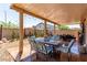 Inviting covered patio featuring an outdoor dining set and desert landscaping at 7824 Warm Winds St, North Las Vegas, NV 89084