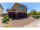 Stunning two-story home featuring a two-car garage and a beautifully paved driveway, surrounded by lush greenery at 7824 Warm Winds St, North Las Vegas, NV 89084