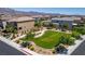Aerial view of the home and neighborhood park, featuring benches, a sidewalk, and a grassy field at 7824 Warm Winds St, North Las Vegas, NV 89084