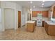 Functional kitchen with an island, tile floors, white appliances, and wooden cabinetry at 7849 Blue Brook Dr, Las Vegas, NV 89147