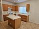 Charming kitchen featuring tile counters, an island, wooden cabinetry, and modern appliances at 7849 Blue Brook Dr, Las Vegas, NV 89147