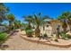 Well-maintained backyard featuring lush landscaping, a gravel area, and mature palm trees, offering a private retreat at 8078 Leather Harness St, Las Vegas, NV 89131