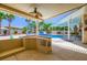 The inviting backyard features an outdoor kitchen, pool, patio, and palms at 8078 Leather Harness St, Las Vegas, NV 89131