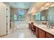 Spacious bathroom with dual sinks, vanity, a walk-in shower, and a soaking tub under a bright window at 8078 Leather Harness St, Las Vegas, NV 89131