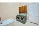 Laundry room with new washer and dryer, utility sink, and upper cabinets at 8078 Leather Harness St, Las Vegas, NV 89131