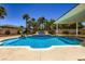 The beautiful backyard has a sparking blue pool, water feature, slide, and lush green landscaping at 8078 Leather Harness St, Las Vegas, NV 89131