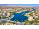 Scenic aerial view of a lakeside community featuring lush landscaping and stunning mountain views at 8100 Lake Hills Dr, Las Vegas, NV 89128