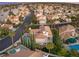 Expansive aerial view of a neighborhood with lush landscaping, pools, and lakes at 8100 Lake Hills Dr, Las Vegas, NV 89128