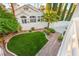 Aerial view of a well-maintained backyard with green lawn, lush landscaping and brick paver hardscape at 8100 Lake Hills Dr, Las Vegas, NV 89128
