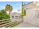 Intimate balcony featuring white railings with views of mature landscaping and the neighbor's home at 8100 Lake Hills Dr, Las Vegas, NV 89128