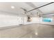 Spacious garage with epoxy flooring, storage, and a large door at 8100 Lake Hills Dr, Las Vegas, NV 89128