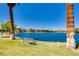 Peaceful lake view with benches, surrounded by mature trees and serene waterfront ambiance at 8100 Lake Hills Dr, Las Vegas, NV 89128