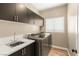 Modern laundry room with stainless steel washer and dryer, sink, quartz countertops, and wood-style flooring at 8100 Lake Hills Dr, Las Vegas, NV 89128
