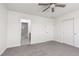 Bright bedroom with carpet, ceiling fan and adjacent bathroom featuring a glass-enclosed shower at 835 Jigglypuff Pl, Henderson, NV 89011