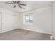 Neutral bedroom featuring carpet flooring, a ceiling fan, and a large window with views at 835 Jigglypuff Pl, Henderson, NV 89011