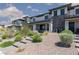 Modern townhome with stone accents, desert landscaping, and a paved walkway leading to the front door at 835 Jigglypuff Pl, Henderson, NV 89011