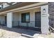 Inviting covered front porch with stone accents and a stylish black metal railing at 835 Jigglypuff Pl, Henderson, NV 89011