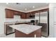 Well-lit kitchen featuring stainless steel appliances, granite countertops, and rich wood cabinetry at 835 Jigglypuff Pl, Henderson, NV 89011