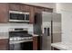 Modern kitchen with stainless steel appliances, granite countertops, and custom cabinets at 835 Jigglypuff Pl, Henderson, NV 89011