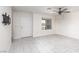 Bright, tiled living room with a modern ceiling fan, window, and white walls at 835 Jigglypuff Pl, Henderson, NV 89011