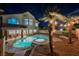 Backyard oasis featuring a pool, palm trees, and backyard lighting at dusk at 8401 Airmont Ct, Las Vegas, NV 89128
