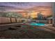 Backyard oasis featuring a refreshing pool, stylish fire pit, and landscaped patio for outdoor enjoyment at 8401 Airmont Ct, Las Vegas, NV 89128