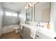 Bright bathroom with marble tiled walls, double vanity and tub with shower at 8401 Airmont Ct, Las Vegas, NV 89128
